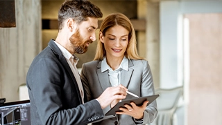 professionally dressed independent insurance agents looking at tablet in insurance office in Florida