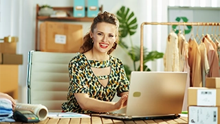 female business owner wearing leopard print sitting in bright office setting with fashionable clothing in background female business owner wearing leopard print sitting in bright office setting with fashionable clothing in background