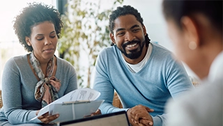 black woman and man reviewing flood insurance paperwork with insurance professional black woman and man reviewing flood insurance paperwork with insurance professional