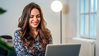 Female homeowners insurance agent on laptop in office space smiling