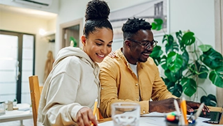 black woman and man dressed comfortably at home looking at flood insurance paperwork black woman and man dressed comfortably at home looking at flood insurance paperwork