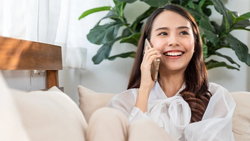 woman talking to independent insurance agent on phone in living