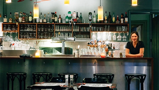 Florida bar owner standing at bar with exposed shelves Florida bar owner standing at bar with exposed shelves