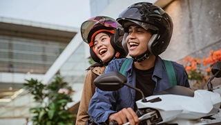 Florida man and woman smiling while wearing helmets on motorcycle