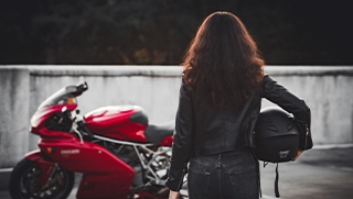 Florida woman holding helmet walking toward red motorcycle