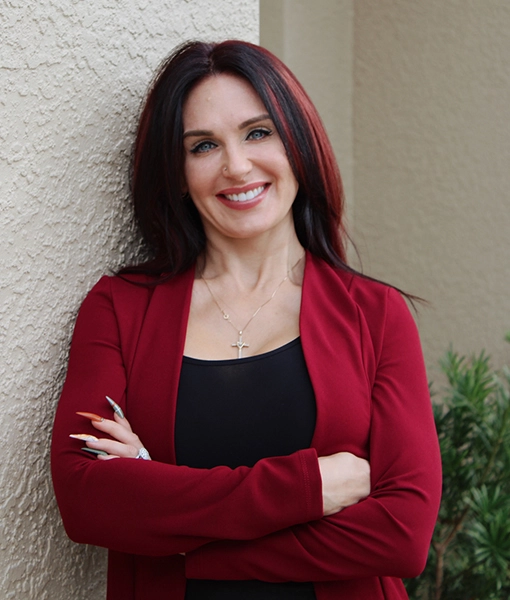 Sam Oxendine, VP of Insurance, smiling standing against outside wall of Florida office location